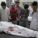 Pakistani Shiite Muslims mourn next to a