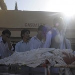 Pakistani Shiite Muslims mourn next to a