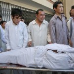 Ethnic Hazara Shi'ite men cry as they move the body of their relative killed in a shootout by unidentified gunmen in Quetta