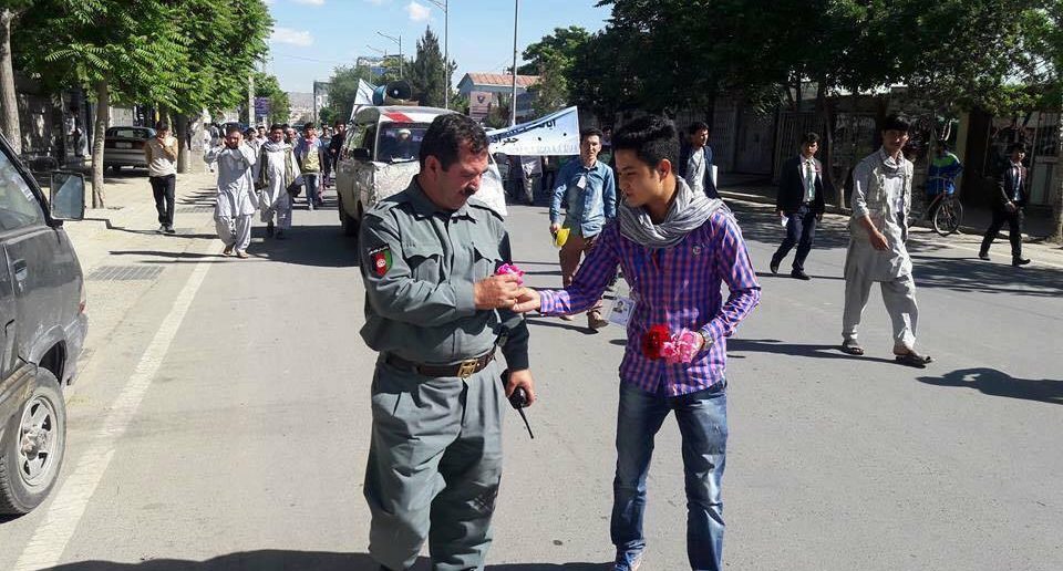 Un manifestante dona un fiore a un poliziotto